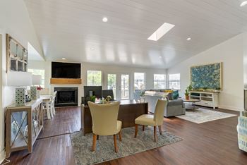 A living room with a fireplace and a dining table.